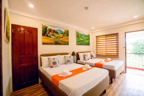 a bedroom with two beds and a window at Villa Lourdes Resort in Panglao