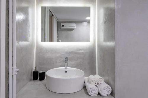a bathroom with a sink and a mirror and towels at Central Elegant Flat in Patra