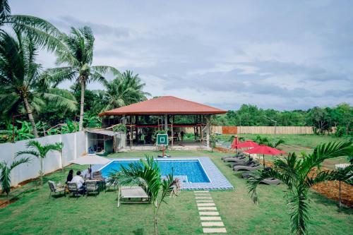 un complexe avec une piscine et un kiosque dans l'établissement Villa Lourdes Resort, à Panglao
