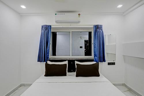 uma cama com duas almofadas num quarto com uma janela em OYO 82287 Hotel Dream 1 Inn em Rāipur