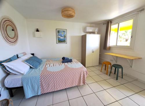 Un dormitorio con una cama y una mesa. en Bungalow Java - Bassin Manapany-Les-Bains en Saint-Joseph
