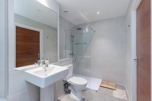 a white bathroom with a sink and a toilet at Hestia Travel London in London