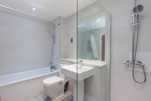 a bathroom with a toilet and a sink and a shower at Hestia Travel London in London