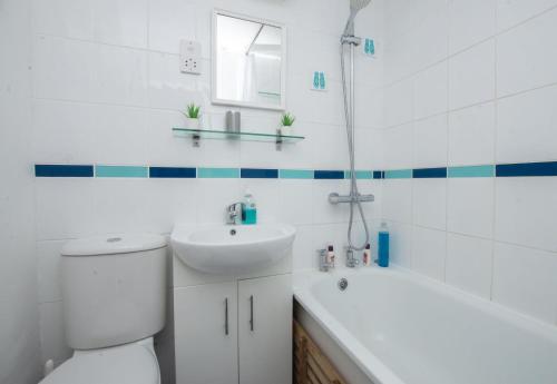 een badkamer met toilet, wastafel en bad bij Chalet One in Deal
