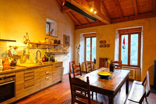 une cuisine avec une table et des chaises dans une pièce dans l'établissement The Mountain Village House, a contemporary house in peaceful mountain village, à Nohèdes