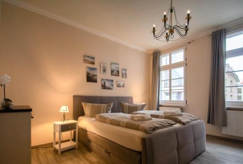 a bedroom with a large bed and a chandelier at Villa Altstadtperle Erfurt in Erfurt