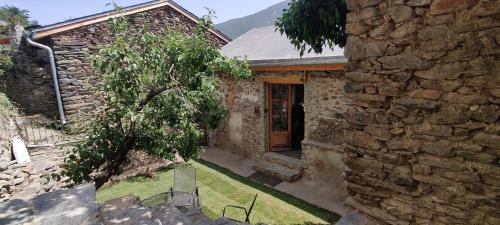 une maison en pierre avec une porte en bois et un mur en pierre dans l'établissement The Mountain Village House, a contemporary house in peaceful mountain village, à Nohèdes