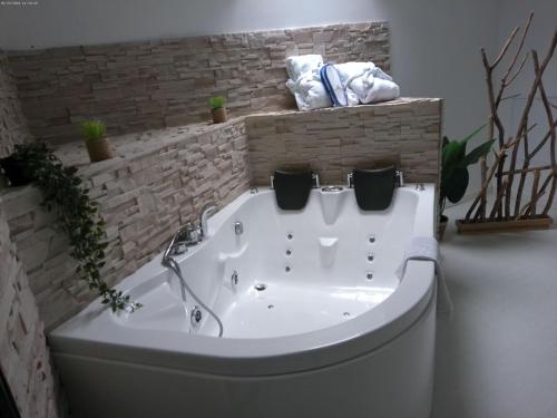 uma banheira branca na casa de banho com toalhas em A 2 pas d AZAY em Neuil