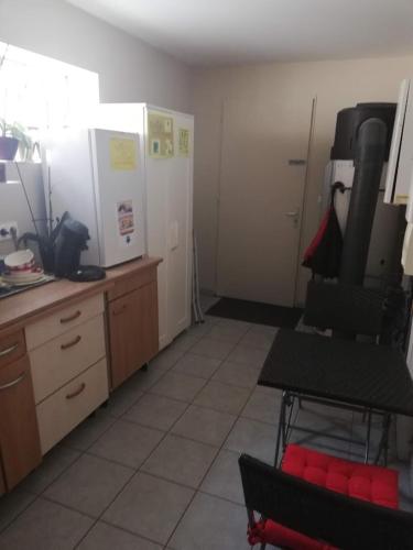 cocina con encimera y silla en una habitación en chambre avec salle de bain privatisée avec petit déjeuner compris, en Auxonne