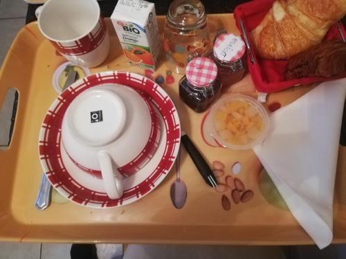 una bandeja con un plato y algo de comida. en chambre avec salle de bain privatisée avec petit déjeuner compris, en Auxonne