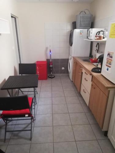 cocina con mesa, sillas y nevera en chambre avec salle de bain privatisée avec petit déjeuner compris, en Auxonne