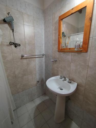 a bathroom with a sink and a shower with a mirror at Departamento El Virula in Villa Unión
