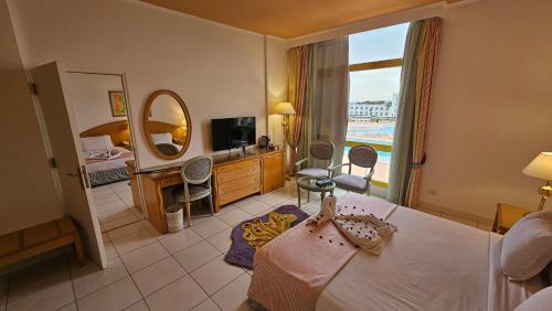 um quarto de hotel com uma cama e uma televisão em Amarina Sun Resort & Aqua Park Sharm El-Sheikh em Sharm el Sheikh