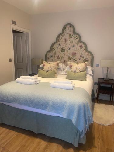 a bedroom with a large bed with a large headboard at The Seagrave Arms in Weston Subedge