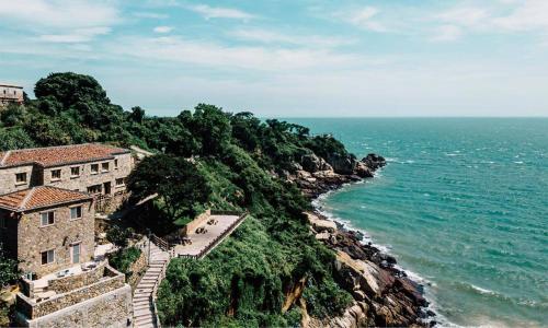 a building on a cliff next to the ocean at 津沙堤岸 in Nangan