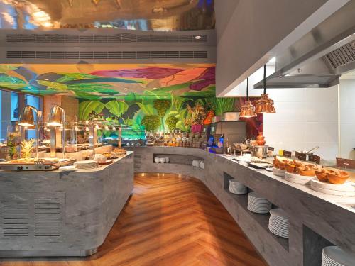 a restaurant with a counter with food on it at NYX Hotel Limassol in Limassol