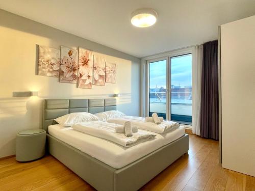 ein Schlafzimmer mit einem großen Bett und einem großen Fenster in der Unterkunft Apartments4you in Wien