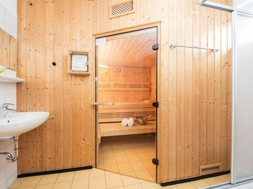 y baño de madera con ducha y lavamanos. en Landal Bad Kleinkirchheim, en Bad Kleinkirchheim