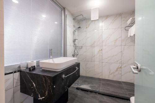 a white bathroom with a sink and a mirror at Suite Rooms By Vvrr in Istanbul