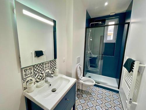 a bathroom with a sink and a toilet and a shower at Pleyel cosy in Saint-Denis