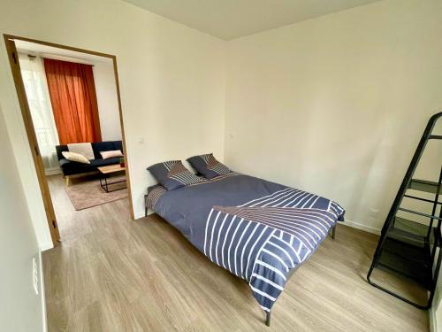 een slaapkamer met een bed in een kamer met een stoel bij Pleyel cosy in Saint-Denis