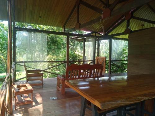 Habitación con porche con mesa de madera y sillas. en Eco Villa Uaturi, en Iquitos