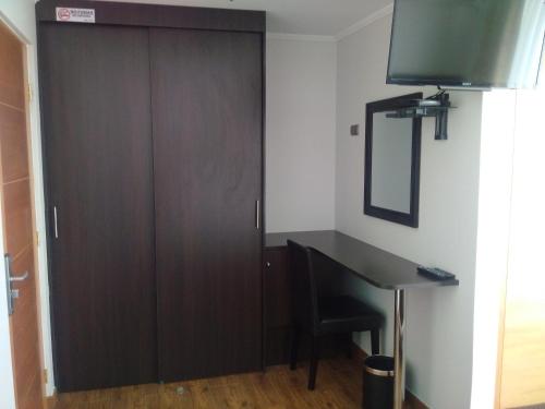 a closet with a desk and a mirror next to a door at Hotel & Spa Las Taguas in Arica