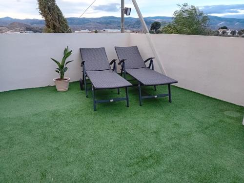 a group of chairs on a patio with grass at Casa nuestro sueño in Partaloa