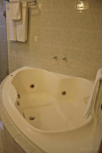 a large white bath tub in a bathroom at Barbur Plaza Hotel in Ponta Grossa