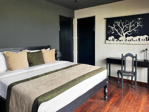 a bedroom with a large bed and a chair at DORMERO Hotel Sri Lanka Hikkaduwa Beach in Hikkaduwa