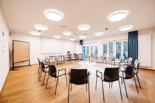 a conference room with chairs and a chalkboard at Hotel Messmer in Bregenz