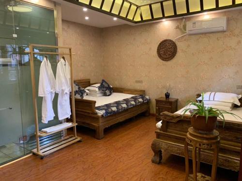 1 dormitorio con 2 camas y ducha de cristal en Pingyao Hongyuyuan Guesthouse, en Pingyao