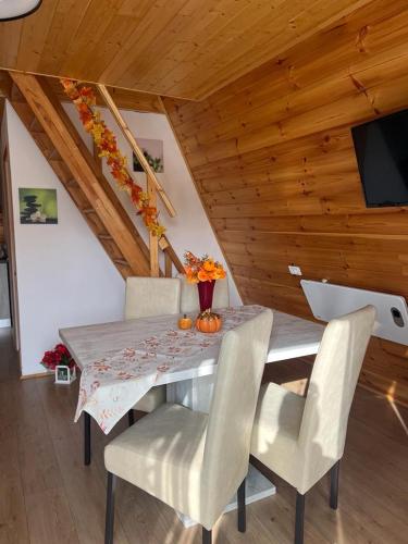 a dining room with a table and chairs at Liniștea Muntilor Cartioasra in Cîrţişoara