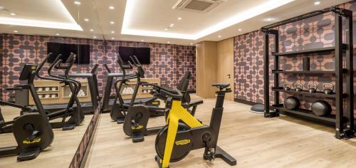 a gym with treadmills and exercise bikes in a room at Ilunion Les Corts Spa in Barcelona