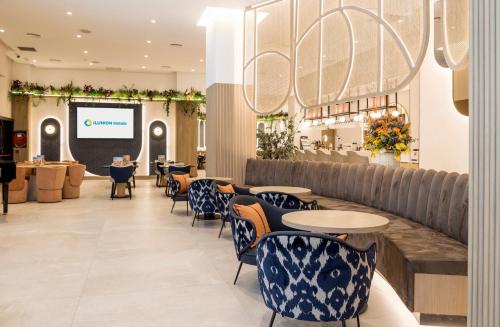 a restaurant with tables and chairs and a screen at Ilunion Les Corts Spa in Barcelona
