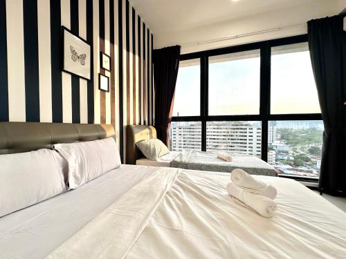 a bedroom with two white towels on a bed at New 2BR or 3BR Homey Getaway stay 7 to 10 pax at Urban Suites, Georgetown by URBAN STAYCATION LOD in Jelutong