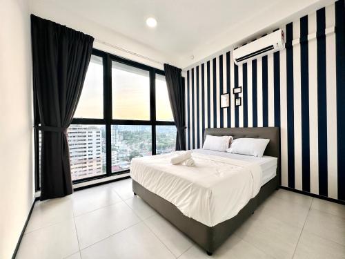 a bedroom with a large bed with black and white stripes at New 2BR or 3BR Homey Getaway stay 7 to 10 pax at Urban Suites, Georgetown by URBAN STAYCATION LOD in Jelutong