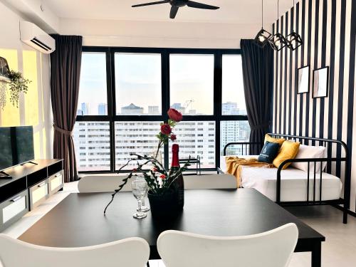 a living room with a table and chairs at New 2BR or 3BR Homey Getaway stay 7 to 10 pax at Urban Suites, Georgetown by URBAN STAYCATION LOD in Jelutong