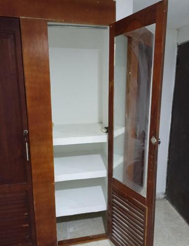 a closet with white shelves and a wooden door at Hermoso y cómodo apartamento in Cartagena de Indias