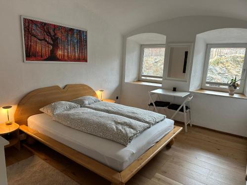 Lambichl的住宿－Wood Apartement，一间卧室设有一张床和两个窗户。