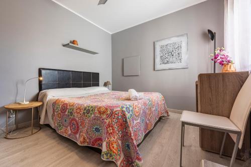 a bedroom with a bed and a chair at Bettatur Apartament Tarraco in Tarragona