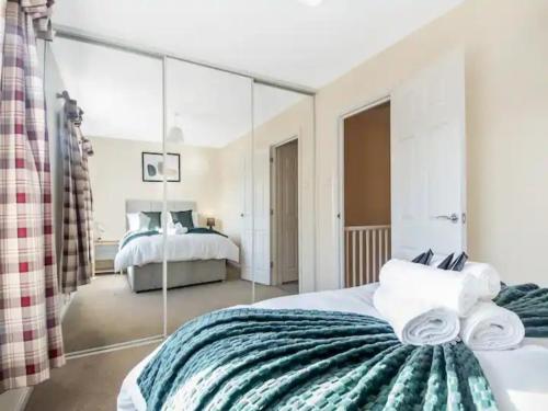 1 dormitorio con espejo grande detrás de la cama en Pass the Keys Cul-de-sac Charm: Terrace Home en Loughton