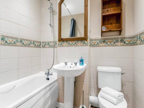 a bathroom with a sink and a toilet and a bath tub at Pass the Keys Cul-de-sac Charm: Terrace Home in Loughton