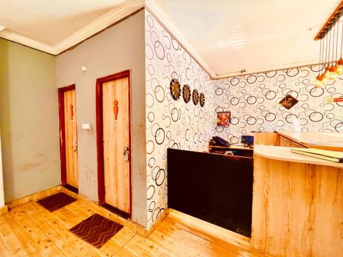 a room with a kitchen with a counter and a wall at Hotel Shivam Inn - Near Calangute Beach in Calangute