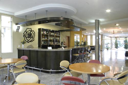 a bar in a restaurant with tables and chairs at Barbur Plaza Hotel in Ponta Grossa