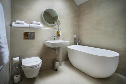 a bathroom with a tub and a toilet and a sink at Willowbeck Lodge Boutique Hotel in Carlisle