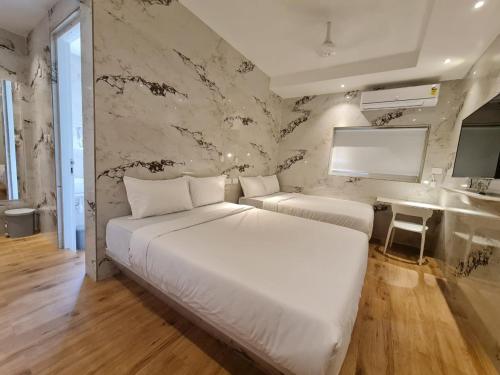 um quarto com 2 camas e um mural de parede em Lotus Rooms@Rockbeach em Pondicherry