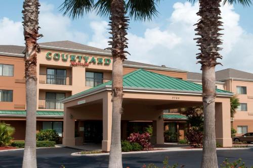 a hotel with palm trees in front of it at Courtyard by Marriott Lakeland in Lakeland