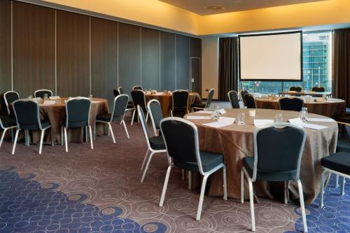 a conference room with tables and chairs and a projection screen at Crowne Plaza Birmingham City by IHG in Birmingham