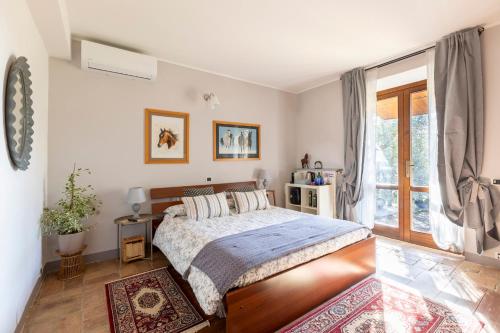 um quarto com uma cama e uma grande janela em B&B La Casetta di Ben em Vetralla